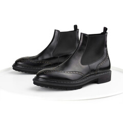 Black brogue chelsea boots on a white background