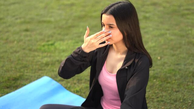 Young indian girl doing yoga, girl doing anulom vilom early in the morning in park. Healthy lifestyle concept.