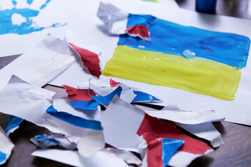 The flag of the Russian Federation is torn to pieces against the background of the Ukrainian flag....