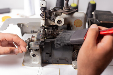 Fototapeta na wymiar cleaning the sewing machine with a brush