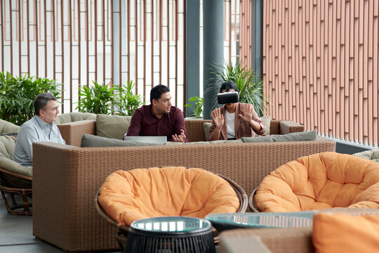 Businesswoman in VR helmet watching virtual reality presentation of new product created by her team - Powered by Adobe