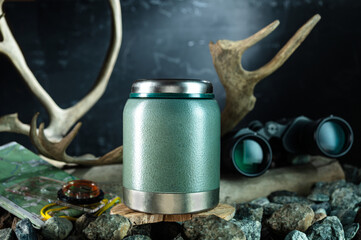 Iron thermos for food storage. Thermos for hunters and tourists. Thermos, compass and map. - obrazy, fototapety, plakaty