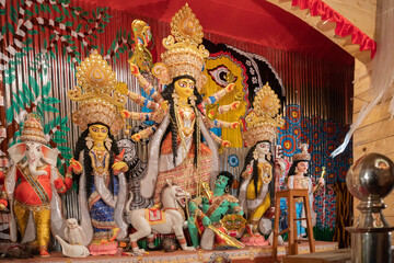 Goddess Durga idol at decorated Durga Puja pandal, shot at colored light, at Kolkata, West Bengal,...