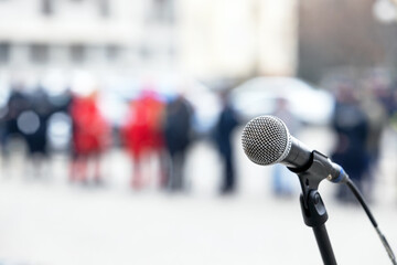 Microphone in focus, blurred people in the background