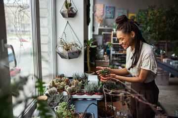 High-spirited florist looking at an exotic plant in her hands