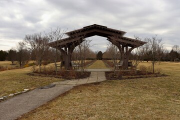 The old wooden arch in the park on a cloudy day.