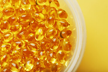 Golden capsules of Vitamin Omega 3 Fish Oil close-up
