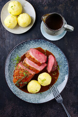 Traditionell gegrilltes Gourmet Entenbrust Filet mit Haut serviert mit Kartoffelknödeln in Dunkelbier Sauce als Draufsicht auf einem Design Teller