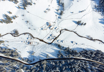 an aerial view with a few houses in a mountainous area in winter