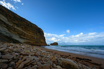 Pebble sandy beach, rocky ocean shore, beautiful ocean view