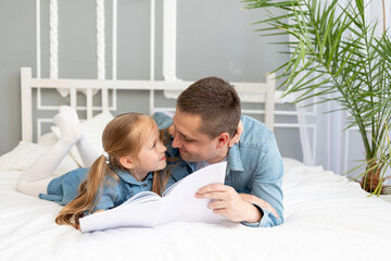 the father reads a book or studies with the daughter's child before going to bed or has fun