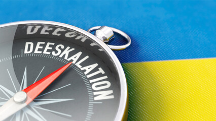 Kompass liegt auf Ukraine-Flagge mit Kompassnadel in Richtung Deeskalation