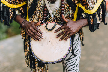 A dark-skinned man, a girl musician plays the enic drum, tambourine, dressed in the national...