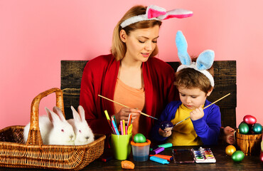 Mother and son painting Easter eggs. Happy Rabbit family with bunny ears. Egg decorating.