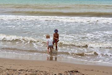 Two little boys are playing on the seashore - 491310403