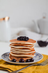 Delicious pancakes with berries for breakfast on a light background.