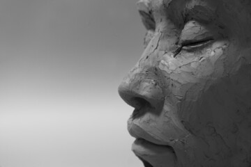 Profile face sculpture. Black and white clay portrait.
