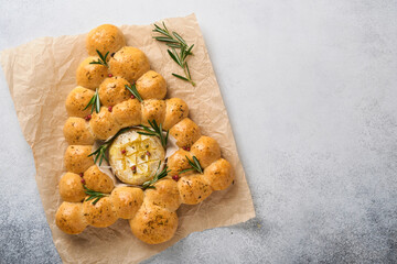 Bread buns Christmas tree with Roasted camembert cheese and rosemary on rustic background. Holiday recipes. Christmas menu. Christmas or Xmas pastries. Top view. Copy Space.