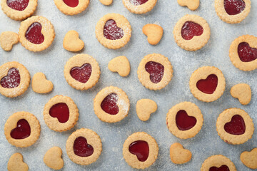 Traditional Linzer cookie with strawberry jam and powder sugar on light grey beautiful background. Top view. Traditional homemade Austrian sweet dessert food on Valentines Day. Holiday snack concept.