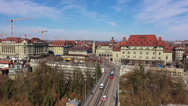 Aerial drone footage of a tram on the Kirchenfeld bridge in Bern historic and city center in Switzerland on a sunny winter day. 