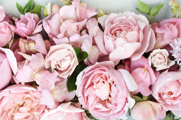 Delicate blooming festive roses and light pink flowers background, blossoming rose flower soft pastel frame, bouquet floral card, selective focus