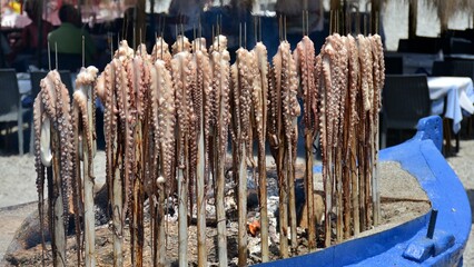 Pulpos preparados para cocinarlos a la brasa, en una barca en la playa
