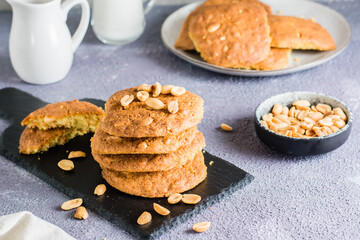 A stack of ready-to-eat fresh peanut cookies on a slate on a table. Homemade pastries