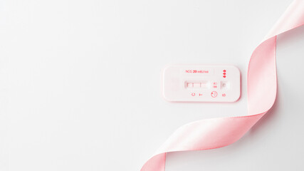 Positive pregnancy test result. Woman pregnant test with pink silk ribbon on white background. Medical healthcare gynecological, pregnancy fertility maternity people concept. © Maksym