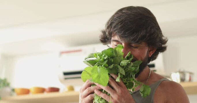 Happy and healthy young man meal prepping whole vegetarian meal in the kitchen. High quality video. Feel good, healthy and health concept.