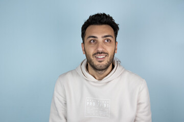 Young boy with serious thoughtful expression on his face. He seems like found an idea or brilliant solution. Friendly gesturing on blue studio background.	