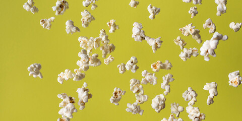 Panoramic banner of  flying homemade popcorn in motion. Popcorn on a yellow background. Close-up,...