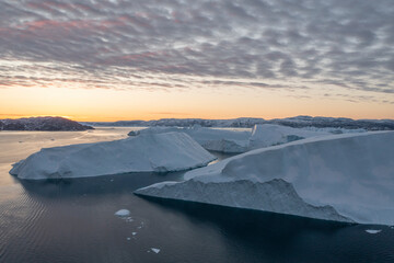 Fototapeta na wymiar enormes icebergs de formas caprichosas flotando sobre el mar desde punto de vista aéreo