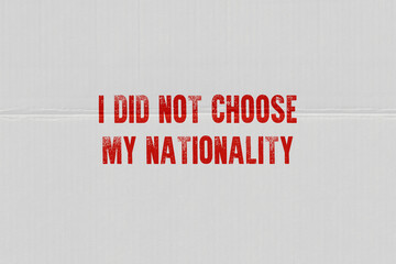 Red inscription on white paper I did not chose my nationality