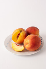 ripe peaches on a plate, white background