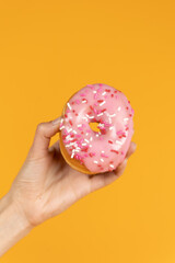 Holding Strawberry Frosted Donut with Sprinkles