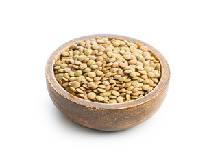Uncooked brown lentils. Raw legume in wooden bowl isolated on white background.