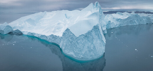 Enormes icebergs flotando en el mar desde punto de vista aéreo. - obrazy, fototapety, plakaty