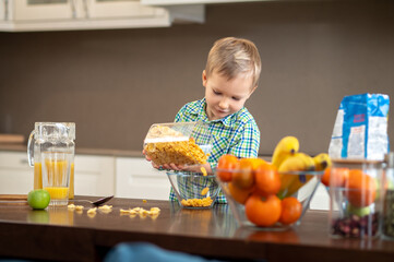 Focused little boy preparing his breakfast in the kitchen