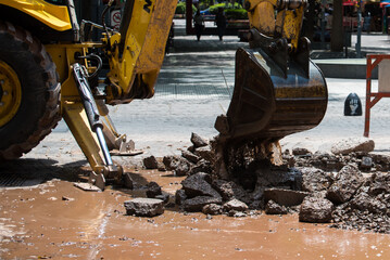 Fototapeta premium bulldozer shovel lifting debris strewn over the street