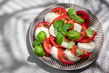 Salad caprese with mozzarella, sliced tomatoes, spices and fresh basil. Home made food. Concept for...