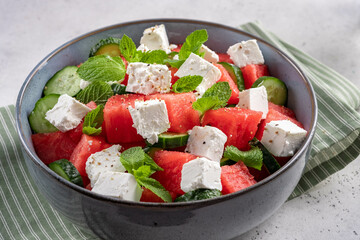 Summer salad with watermelon, mint, cucumber and feta cheese close up. Shadows