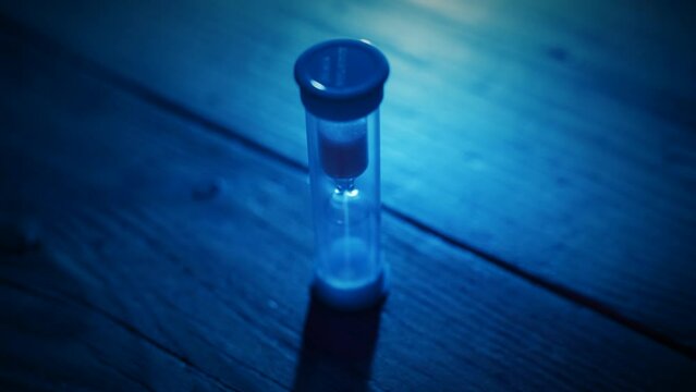 Close up of hand turning over egg timer