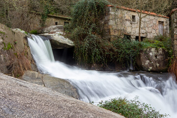 Obraz premium waterfall that flows into a lake near some houses