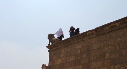 Arabic women with Lion statue on a wall