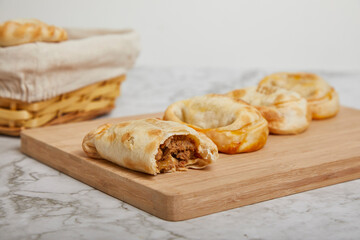 Argentinian Empanadas on a wooden board on a marble table