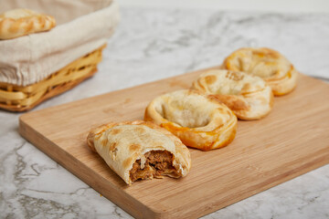 Argentinian Empanadas on a wooden board on a marble table