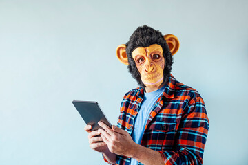 Man in monkey mask using tablet.