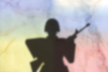 Silhueta de soldado em desfoque por cima de um fundo de fumos com cores azul, amarelo, branco, vermelho - obrazy, fototapety, plakaty