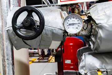 Barometers on pressure pipes, underground premises of the factory with heat and water distribution...