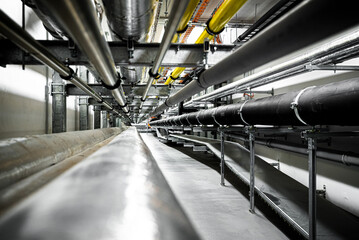 Gas and waste pipelines in the underground premises of the factory, industrial background, building...